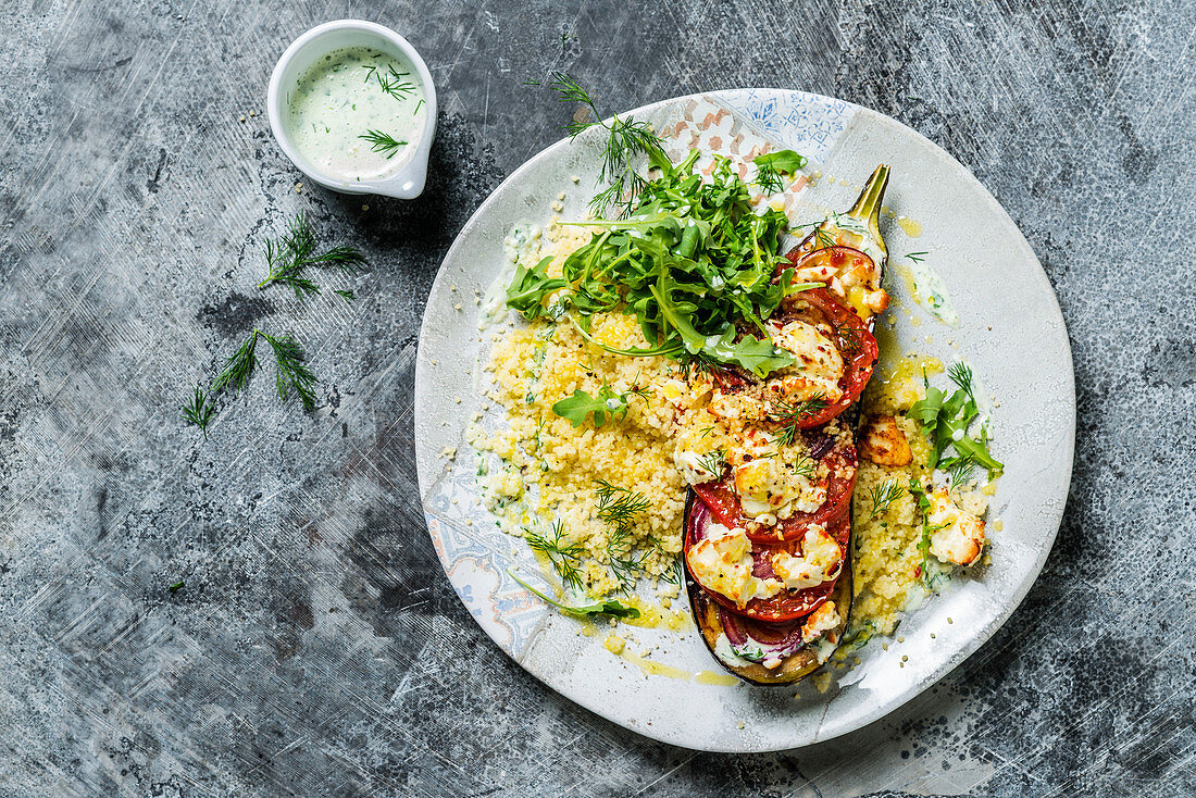 Aubergine stuffed with tomatoes and feta, served with couscous