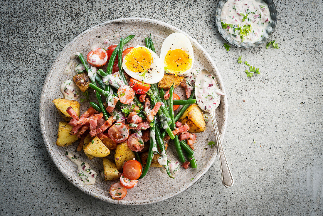 Salat mit Kartoffeln, Speck, grünen Bohnen und gekochten Eiern