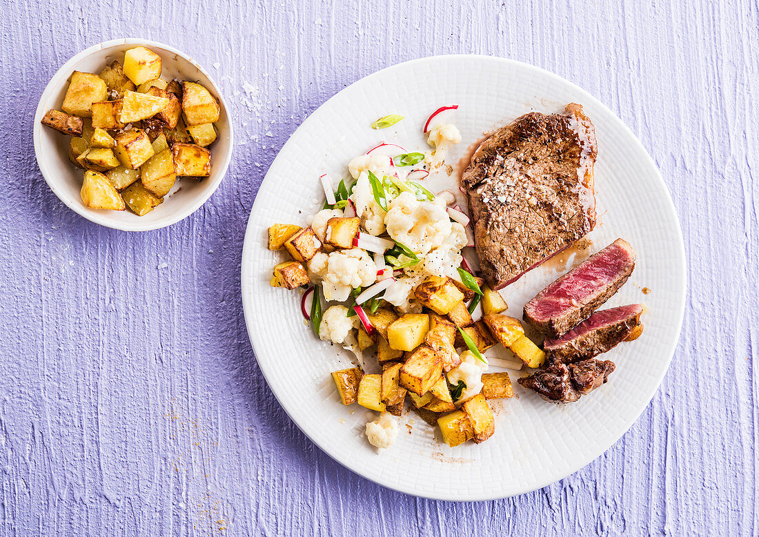 Steak with cauliflower salad and fried potatoes