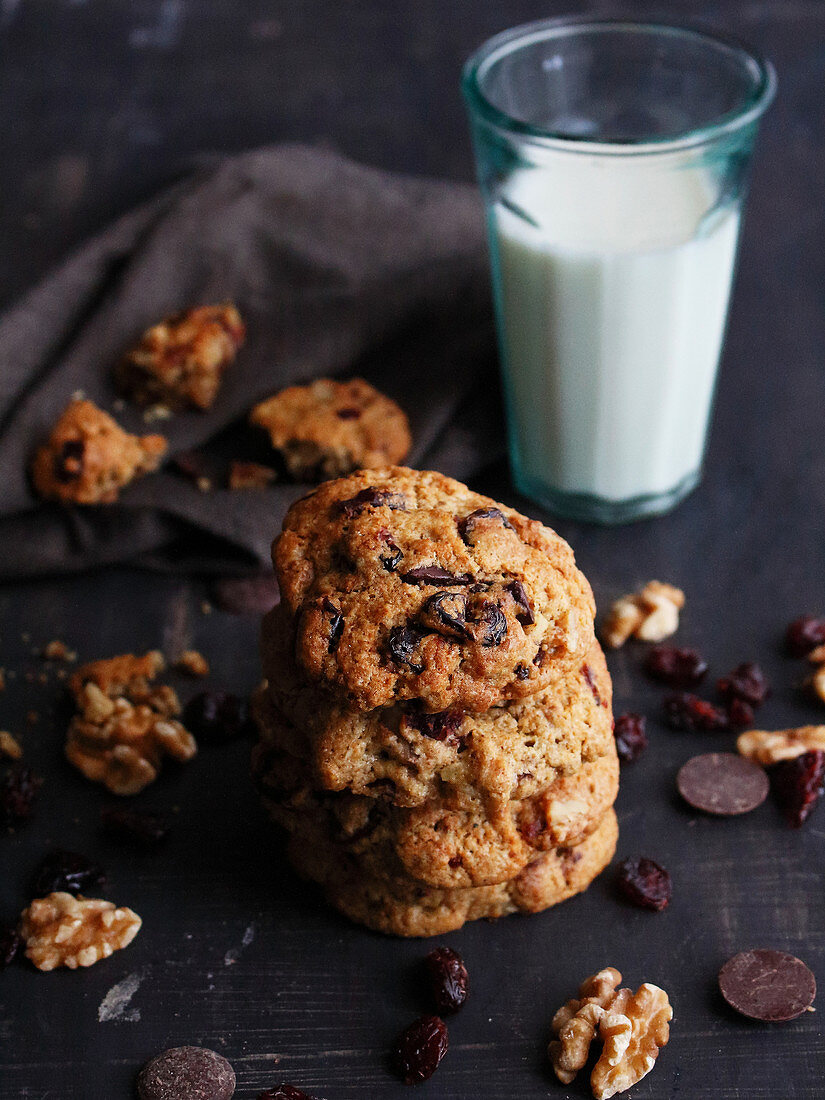Cookies with cranberries, chocolate, and nuts served with a glass of milk