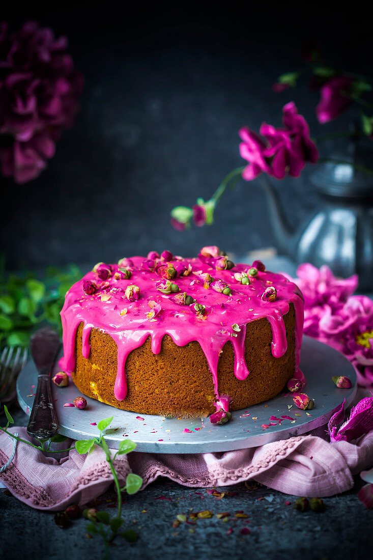 Coconut cake decorated with pink rose water icing and rose petals