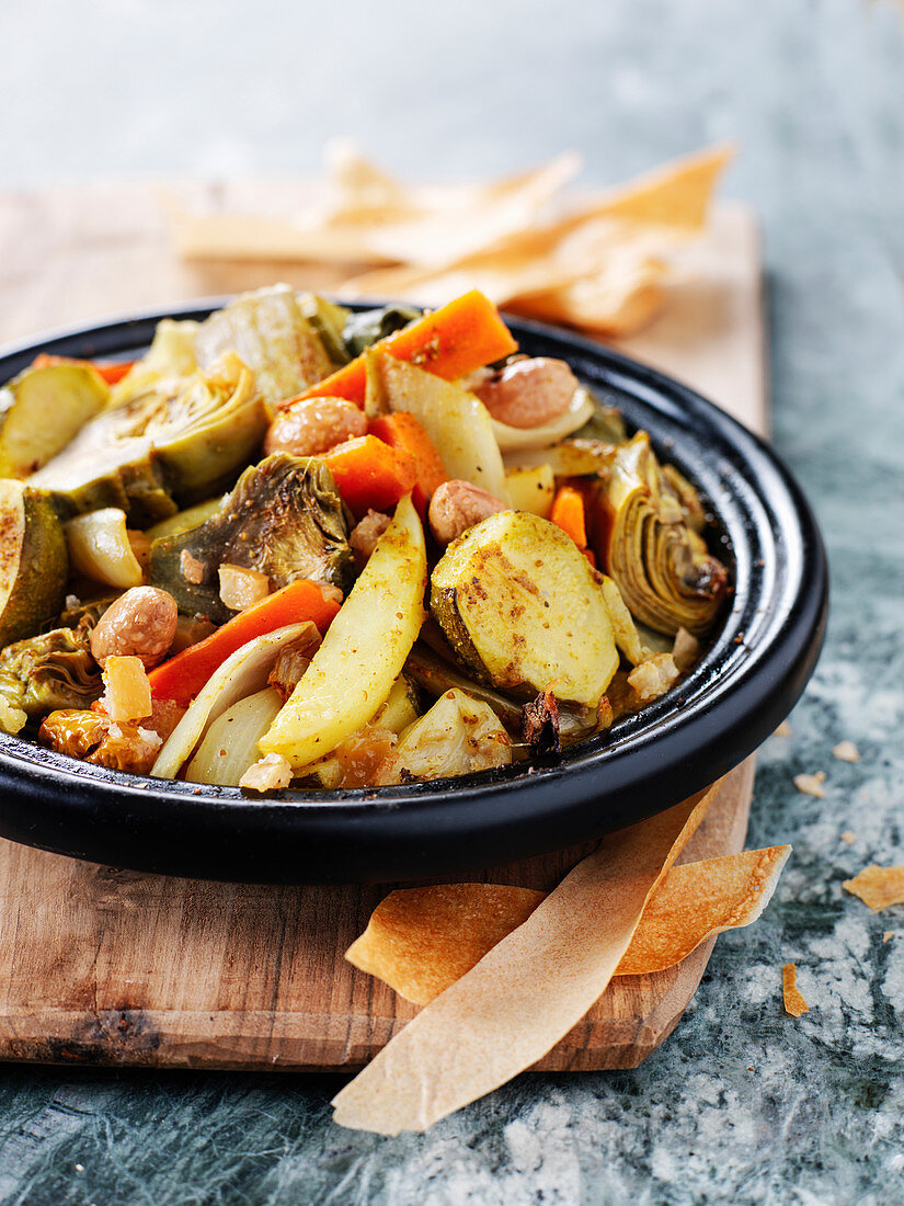 Vegetable tagine with round courgettes, artichokes, carrots, fennel and olives