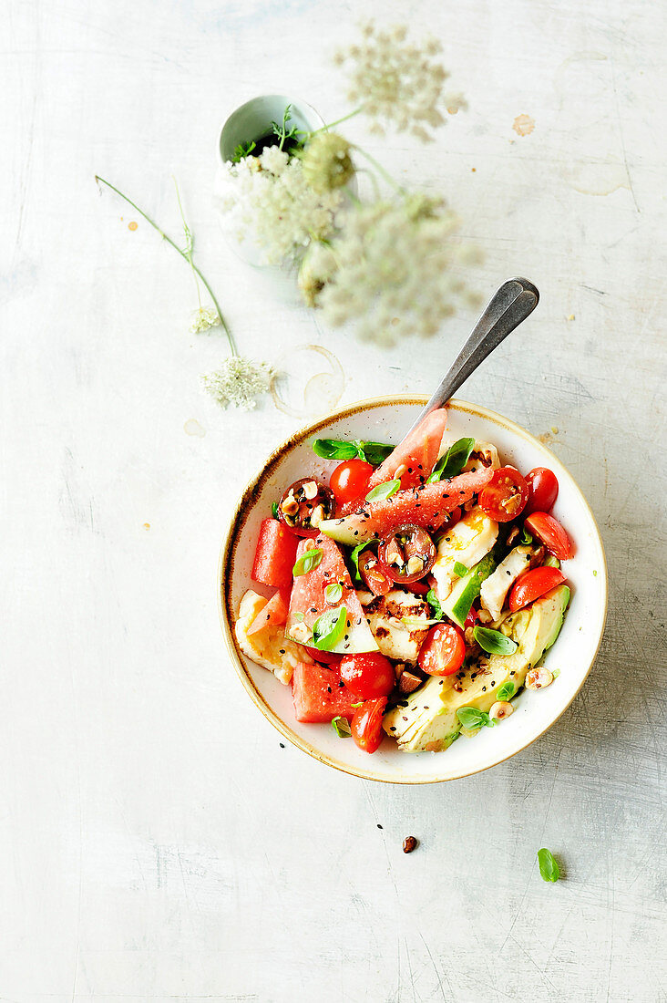 Summer salad with cherry tomatoes, avocado and watermelon