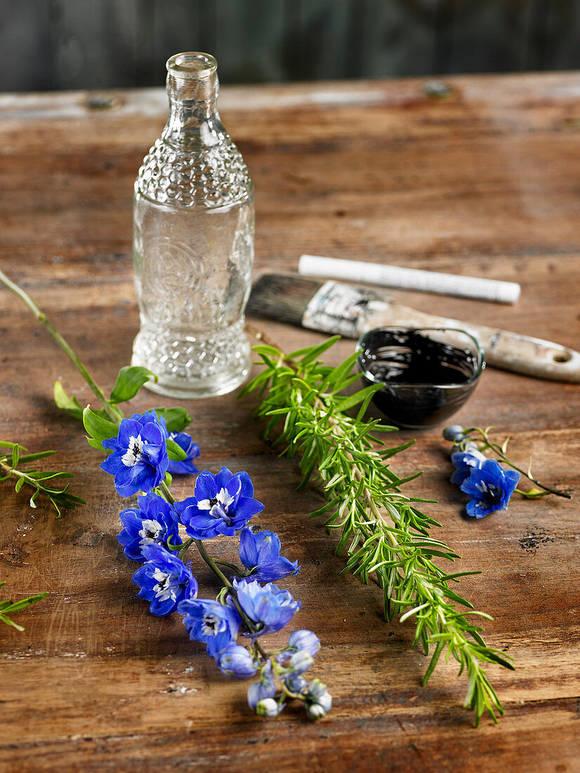 Bastelmaterial: Blütenzweige, Kräuterzweige, Glasflasche und Farbe