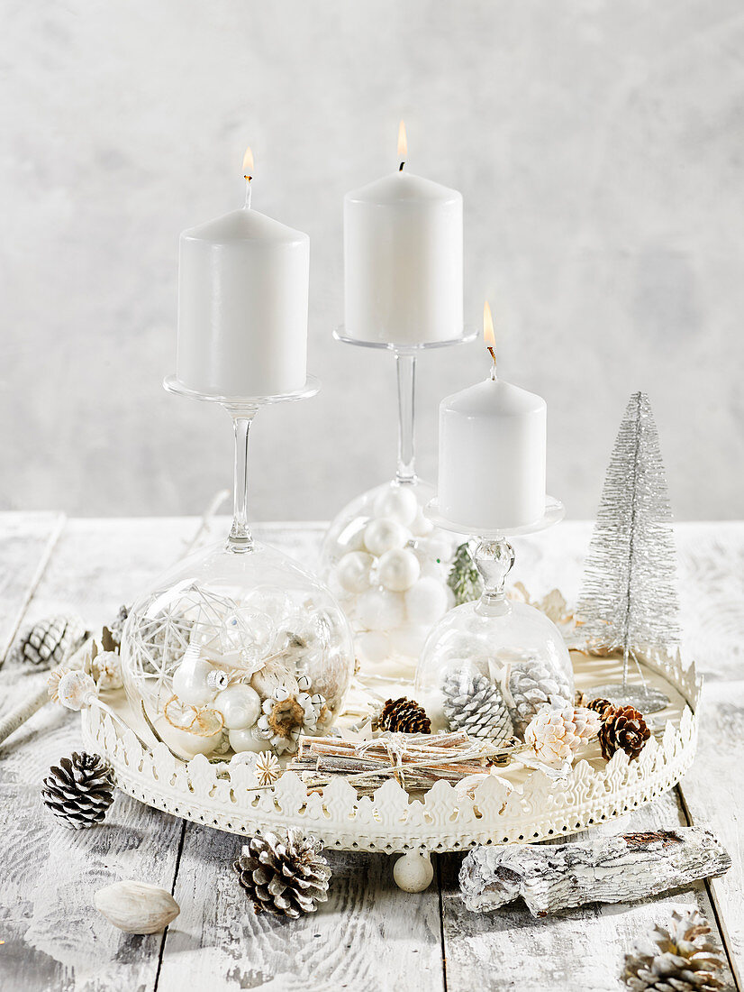 Weihnachtlich dekorierter Tisch in Weiß mit Weingläsern als Kerzenhaltern