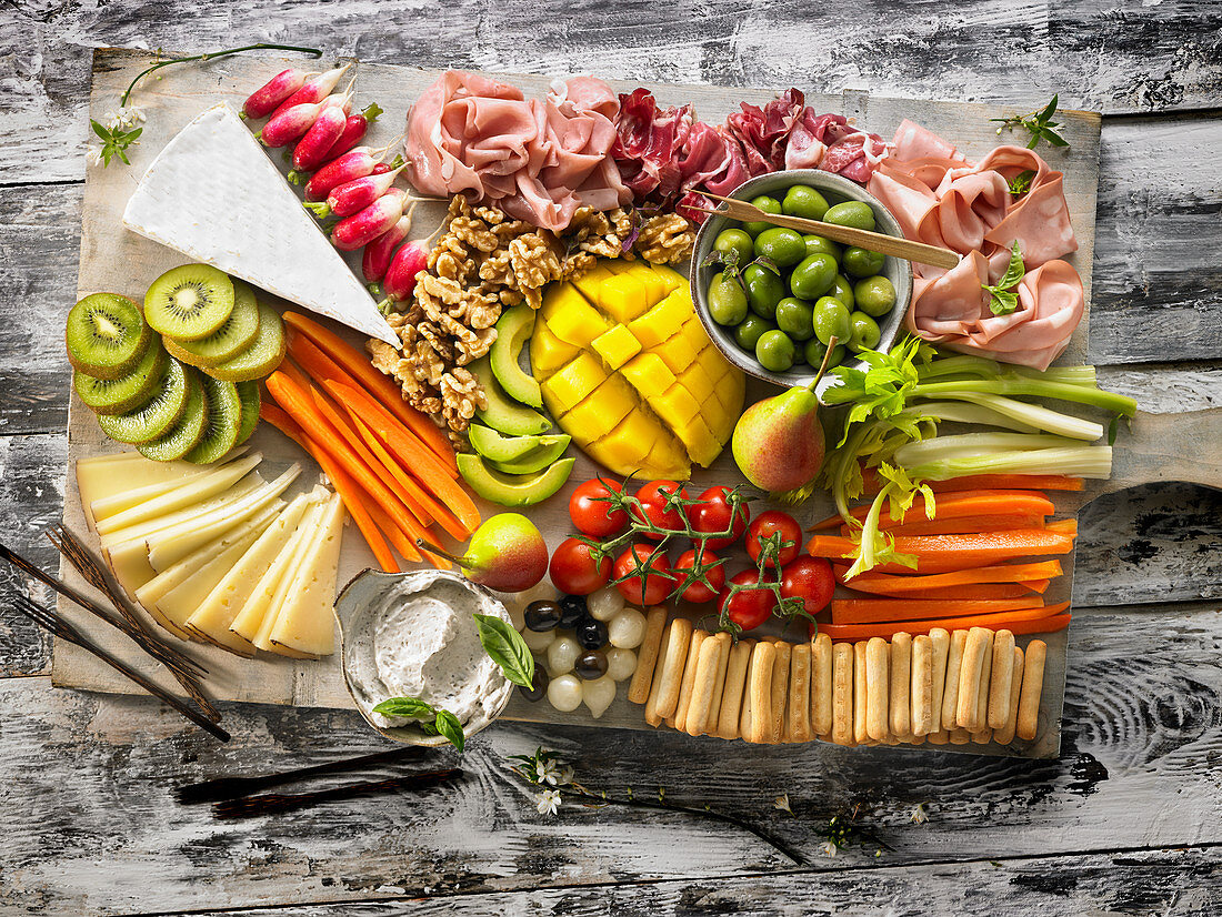 Vorspeisenplatte mit Gemüse, Käse, Aufschnitt, Obst und Crackern