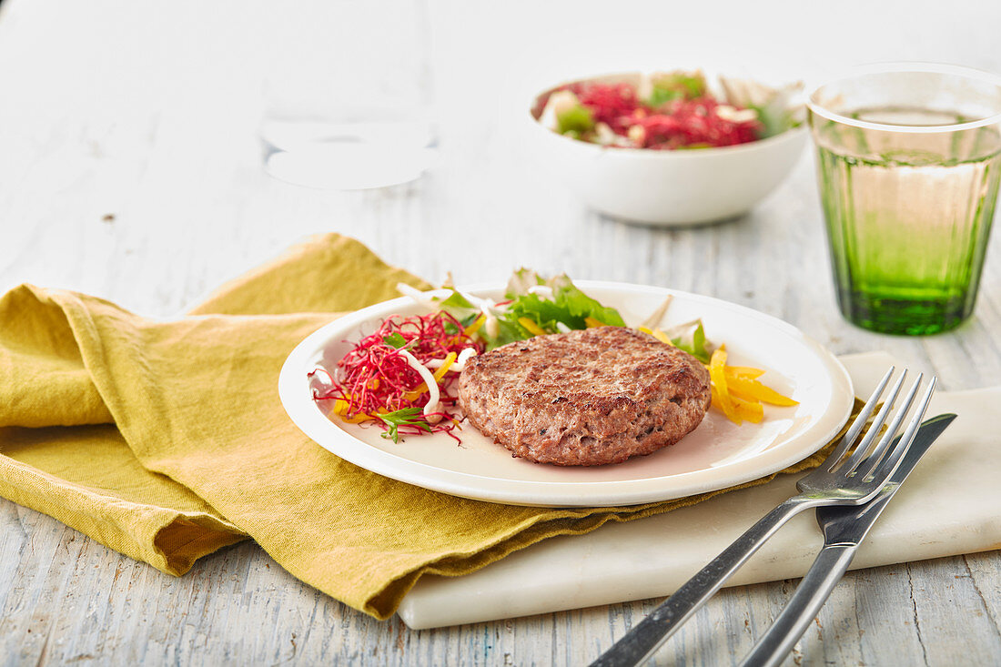 Hamburger pattie with sprout salad