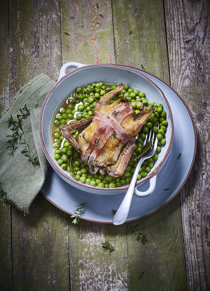 Chicken wrapped in bacon with peas