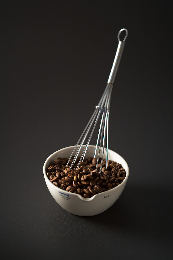 Coffee beans with a whisk in a bowl