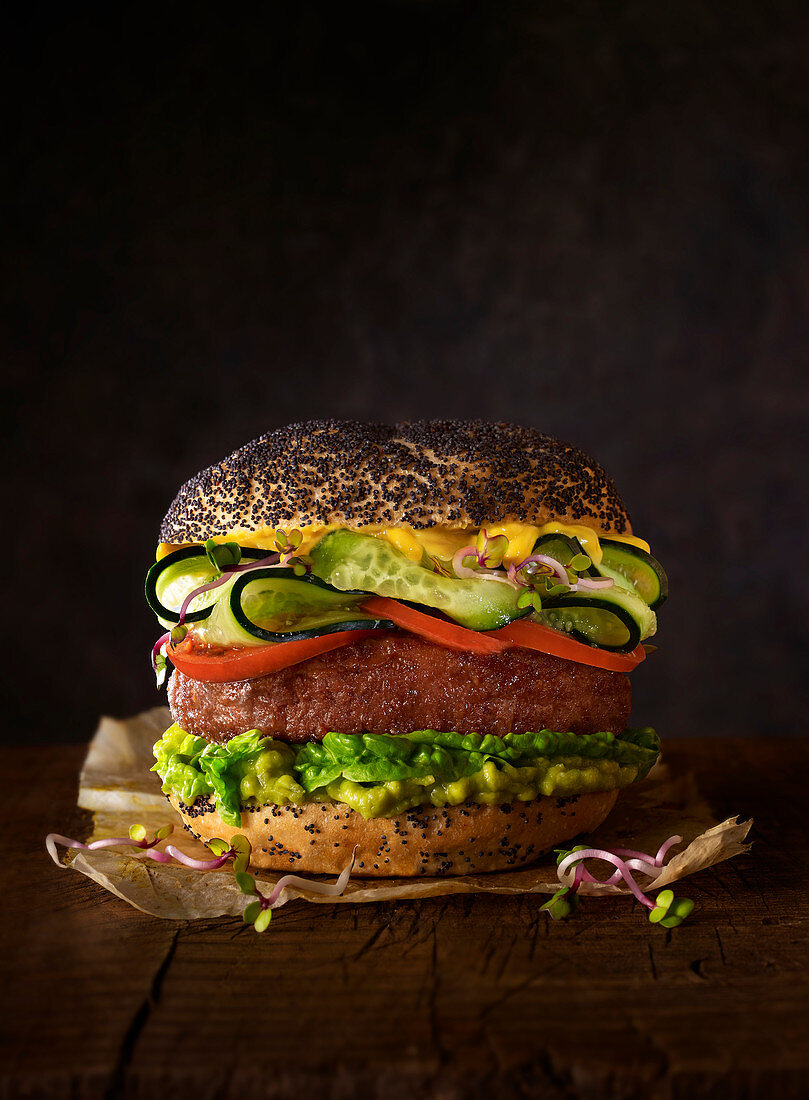 Burger with poppy seed bread, guacamole, beef, cucumber