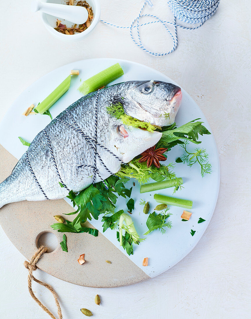 Roher Fisch gefüllt mit Stangensellerie und Kräuter