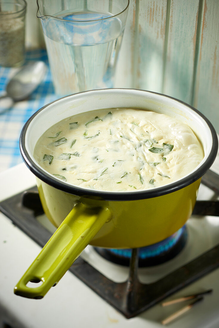 Joghurtsuppe mit Estragon im Stieltopf auf Gasherd