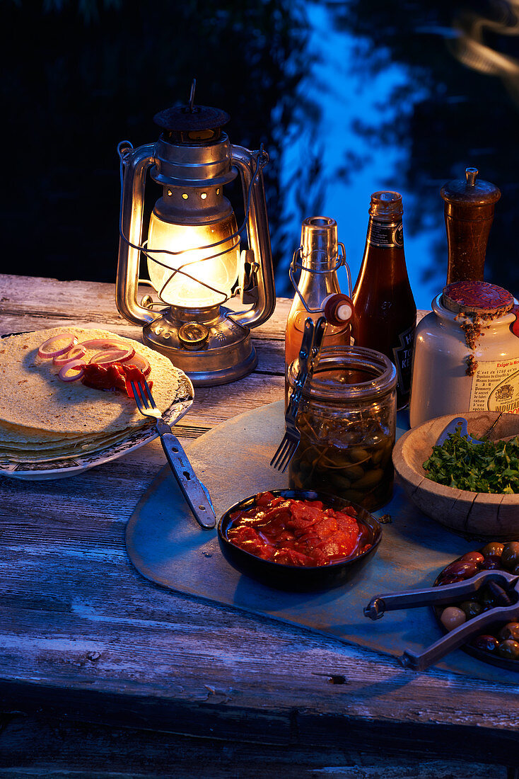 Fajitas mit Zutaten auf Tisch im Freien bei Abendstimmung