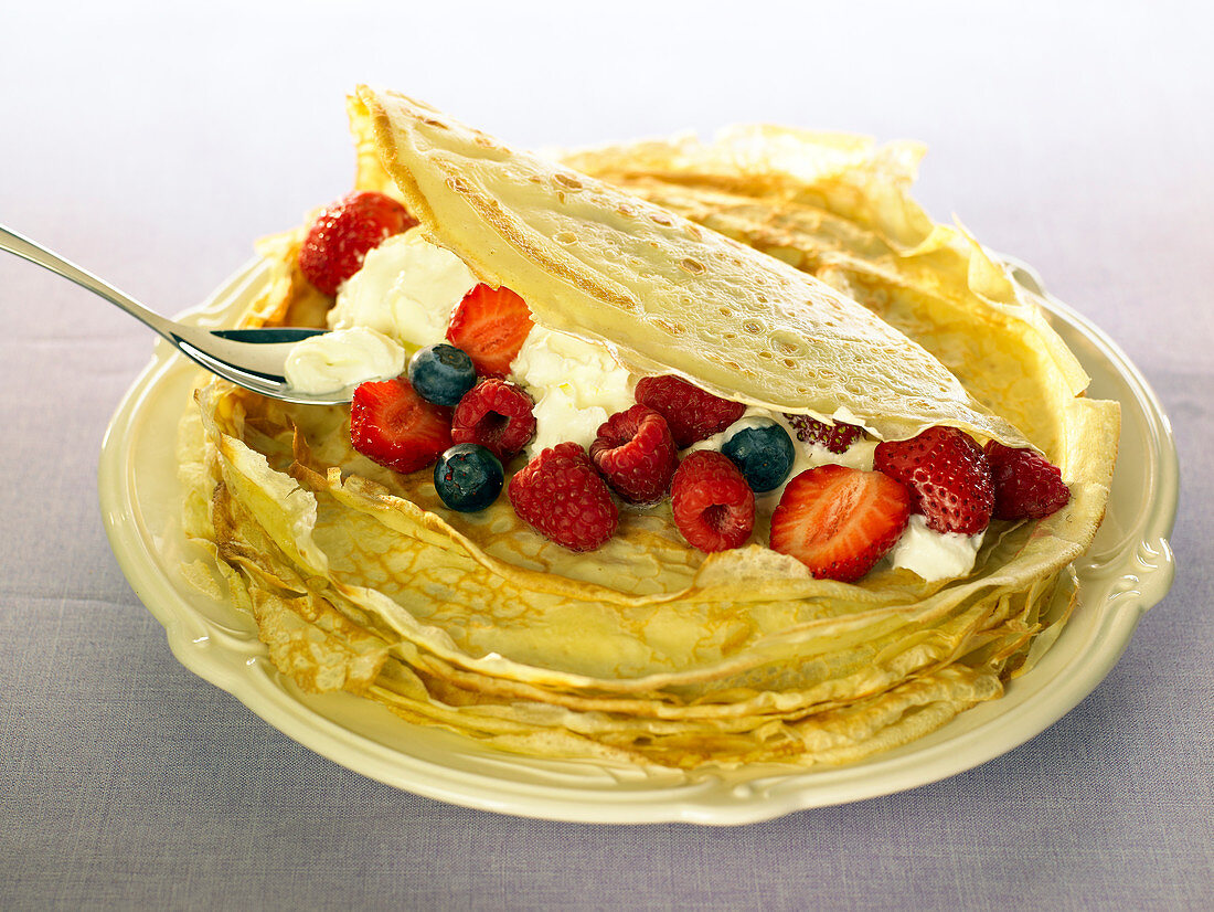 Crêpes garnished with cream and berries