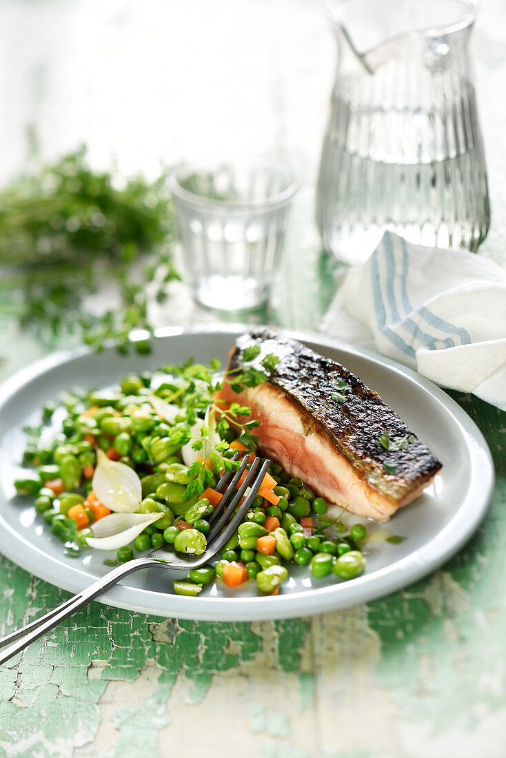 Half-cooked salmon with broad beans,carrots and peas