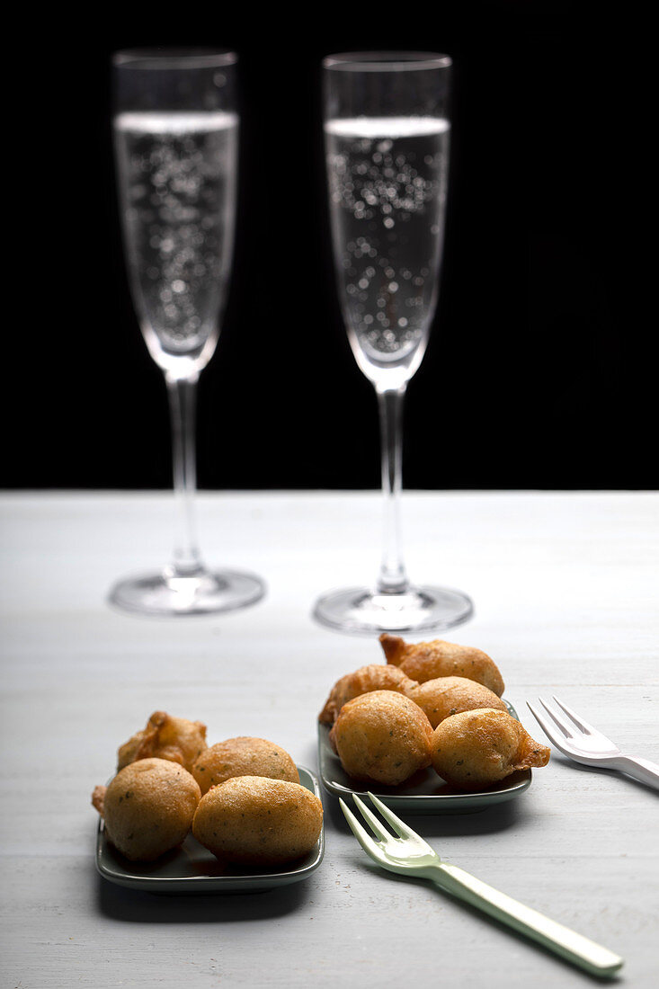 Cod fritters and glasses of Champagne on a white background