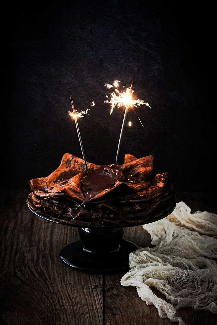 Ein Stapel Schokoladenpfannkuchen mit Wunderkerzen