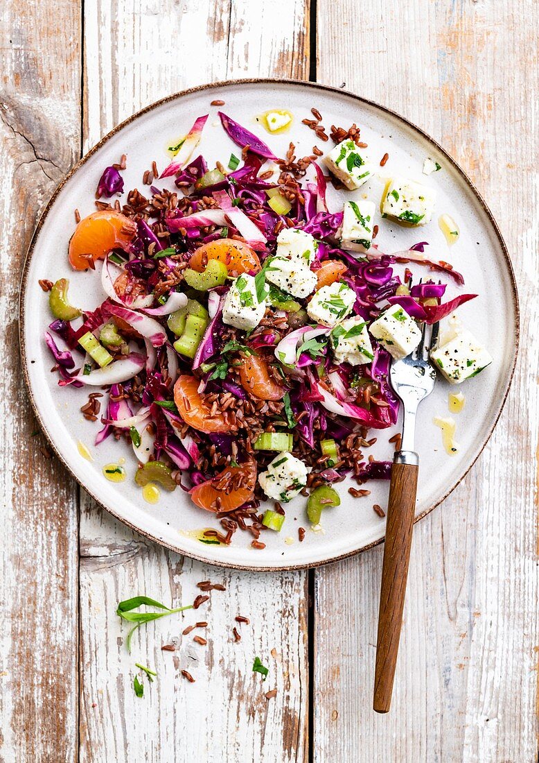 Red rice salad with red cabbage, clementines and feta cheese