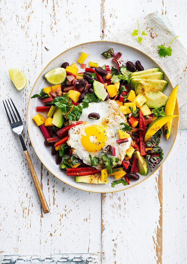 Mexican salad with mango, avocado, kidney beans and fried egg