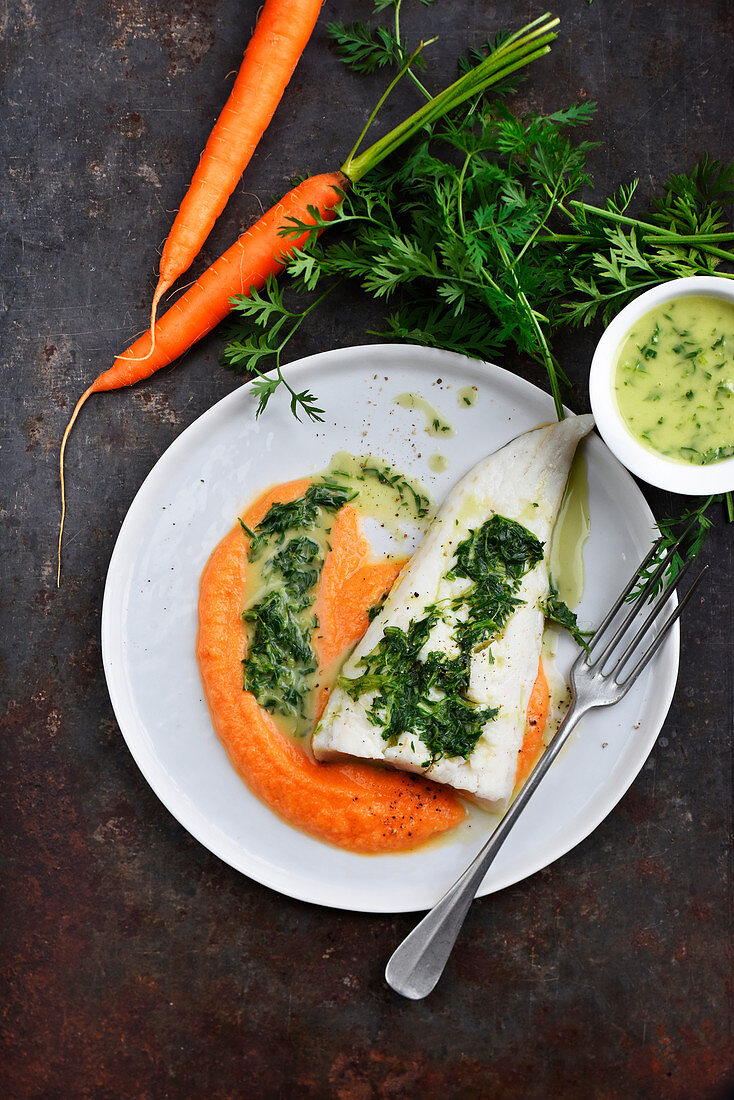 Hake fillet with mashed carrots,butter sauce and carrot tops