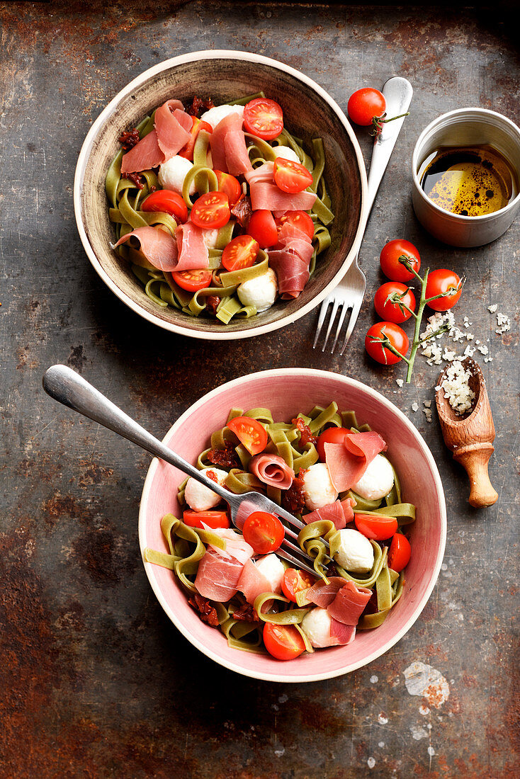 Italienischer Nudelsalat mit grünen Tagliatelle, Schinken, Tomaten und Mozzarella