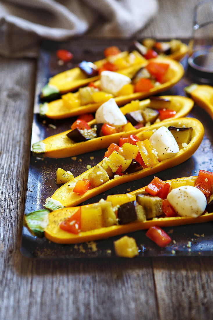 Gelbe Zucchini gefüllt mit Gemüse und Mini-Mozzarella