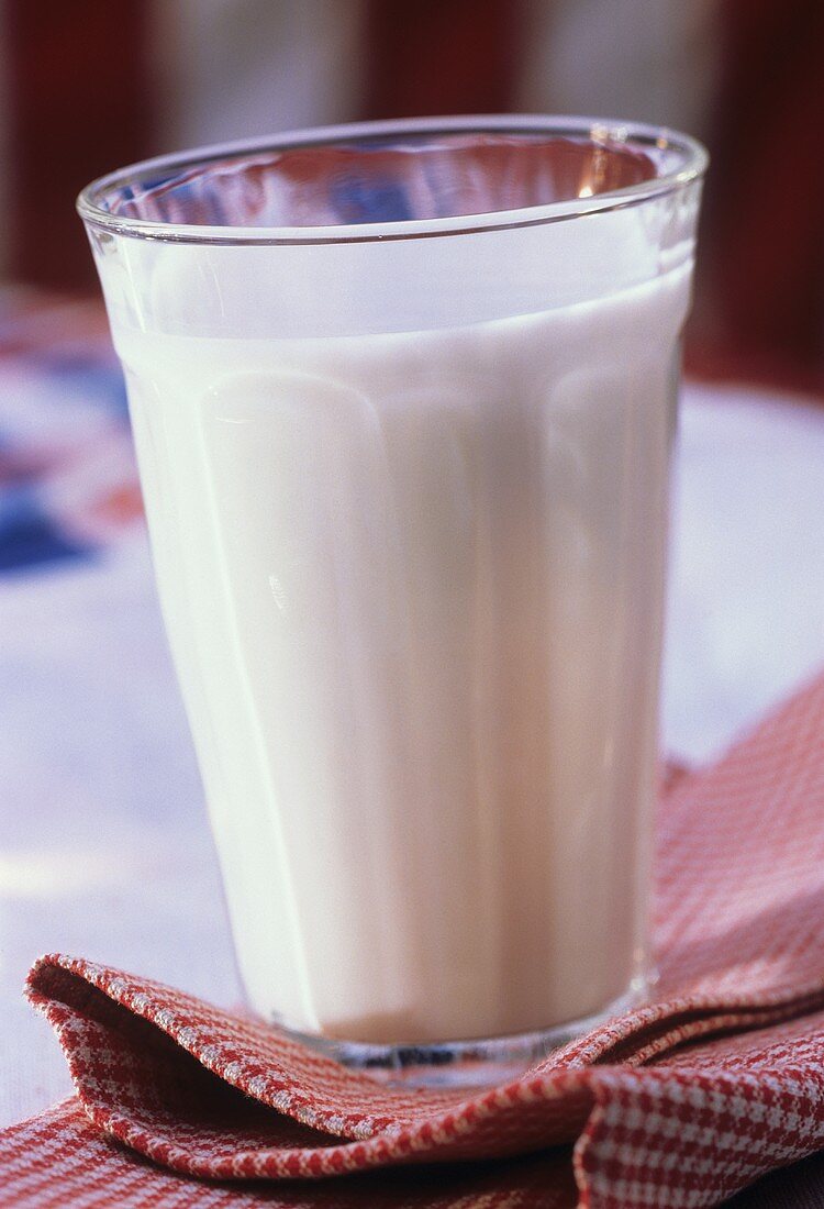 Ein Glas Milch auf rot-weiss karierter Serviette