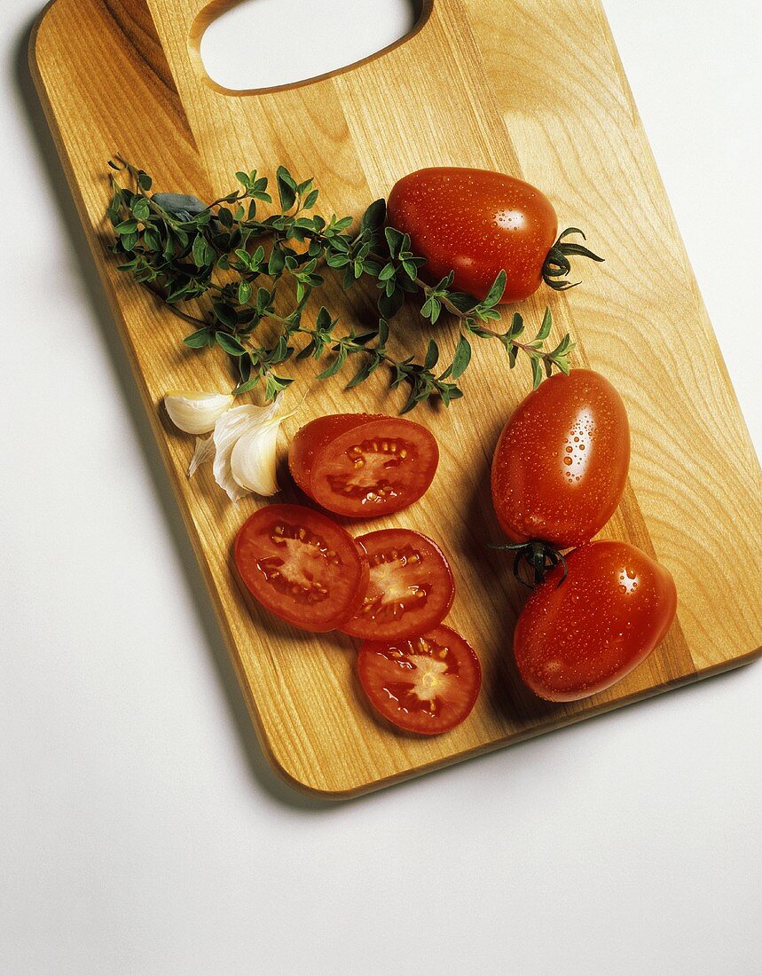 Plum Tomatoes on Cutting Board; Garlic and Oregano