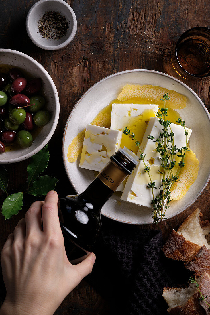 Feta cheese marinated with bay leaves, thyme, lemon zest and black pepper, served with green olives and kalamata olives