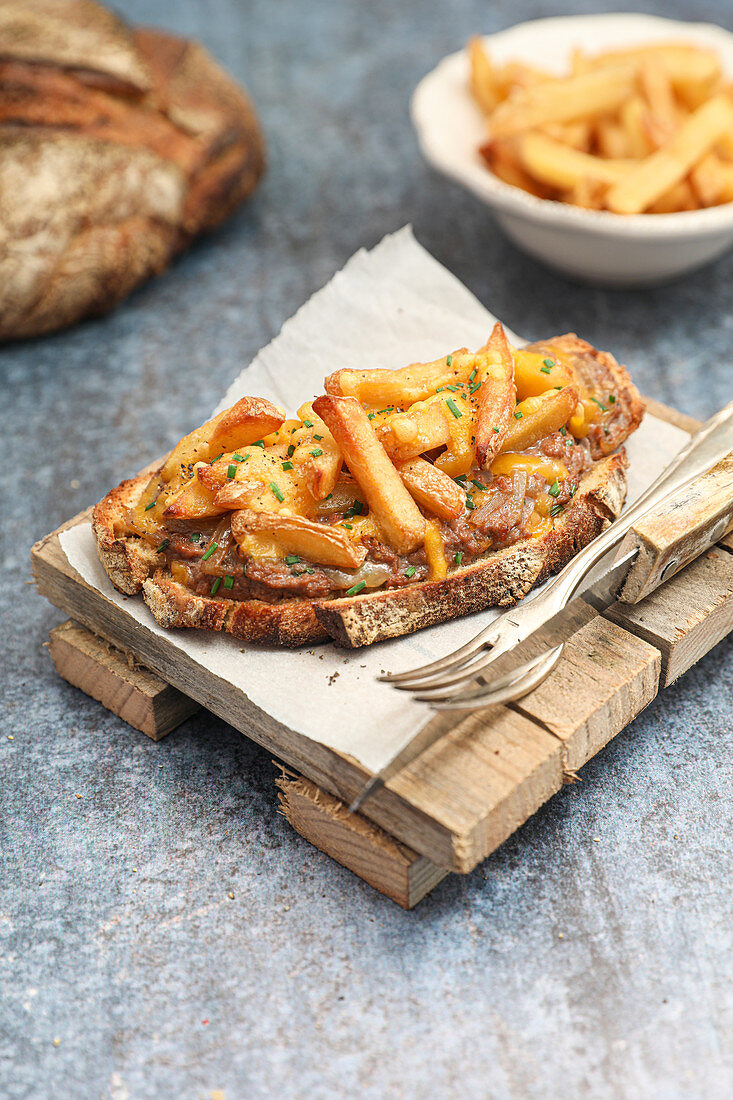 Grilled ground beef and French fries au gratin with cheddar cheese