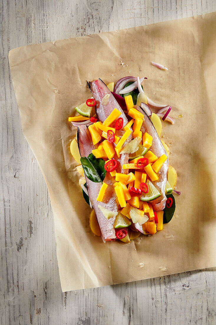 Preparing fish fillets in foil with crunchy vegetables