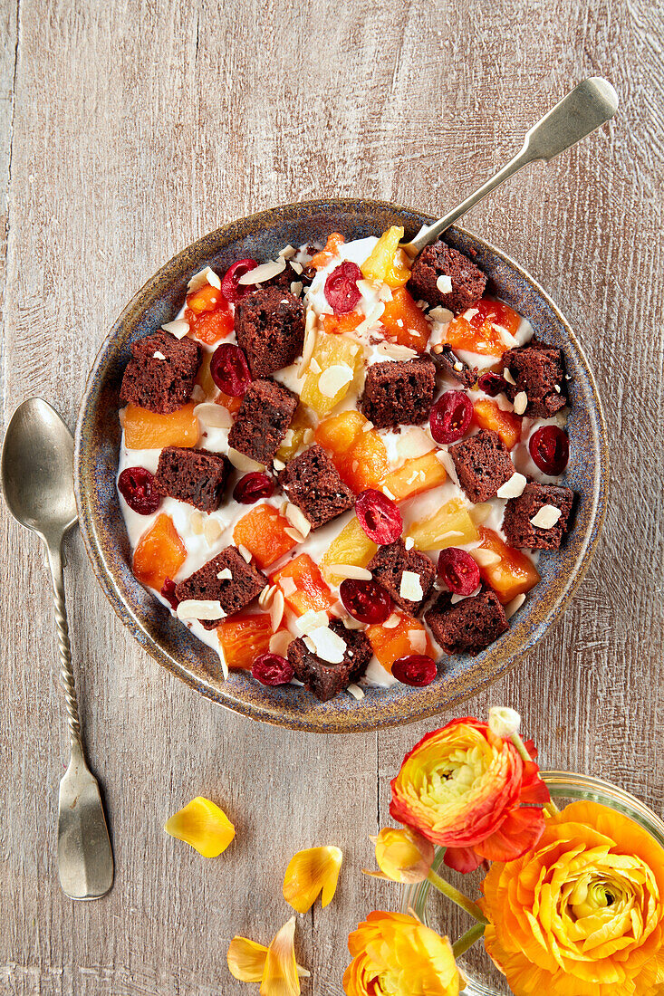 Curd dessert with brownies, fruit and almonds