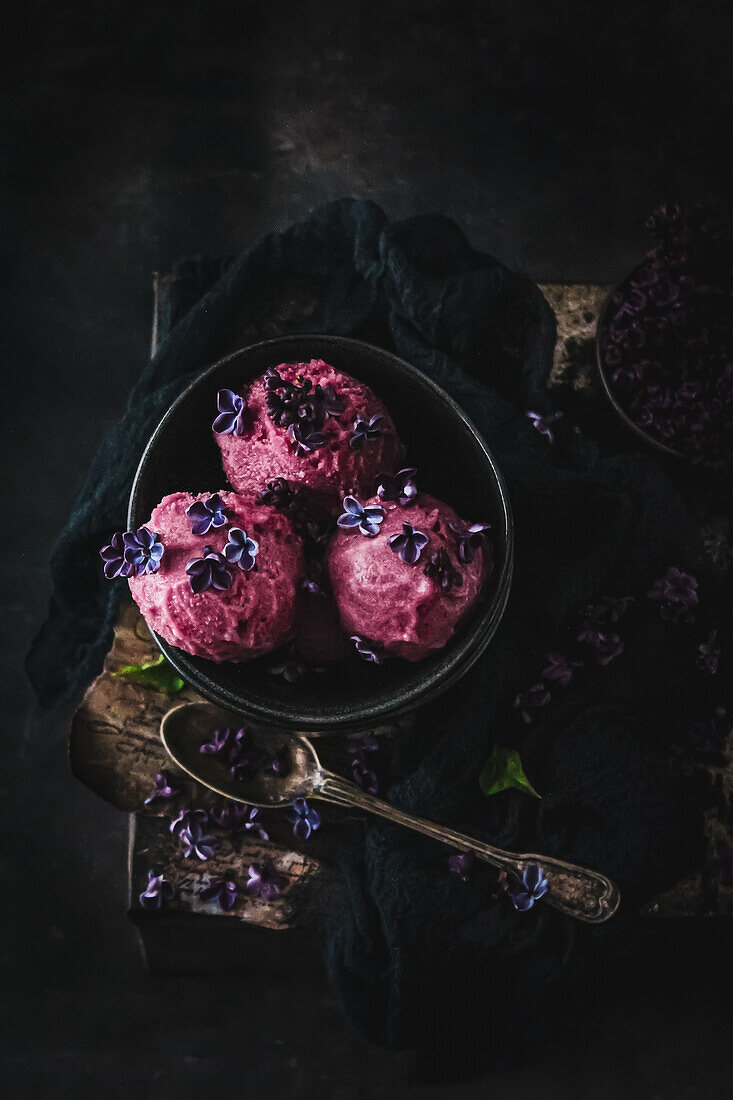 Raspberry ice cream scoops with lilac blossoms