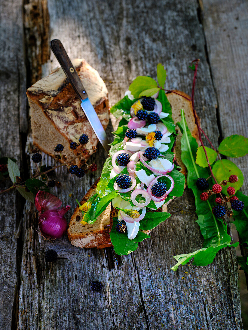 Bread topped with dandelion, goat cheese and blackberries