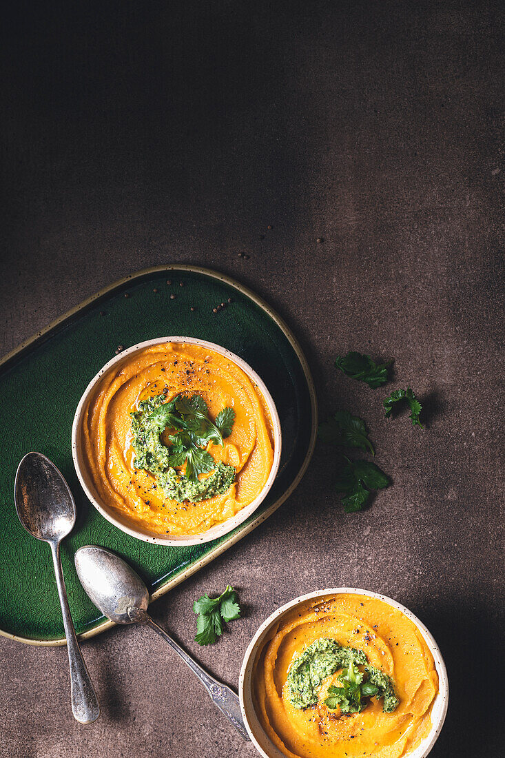 Cream of carrot soup with coral lentils and coriander pesto