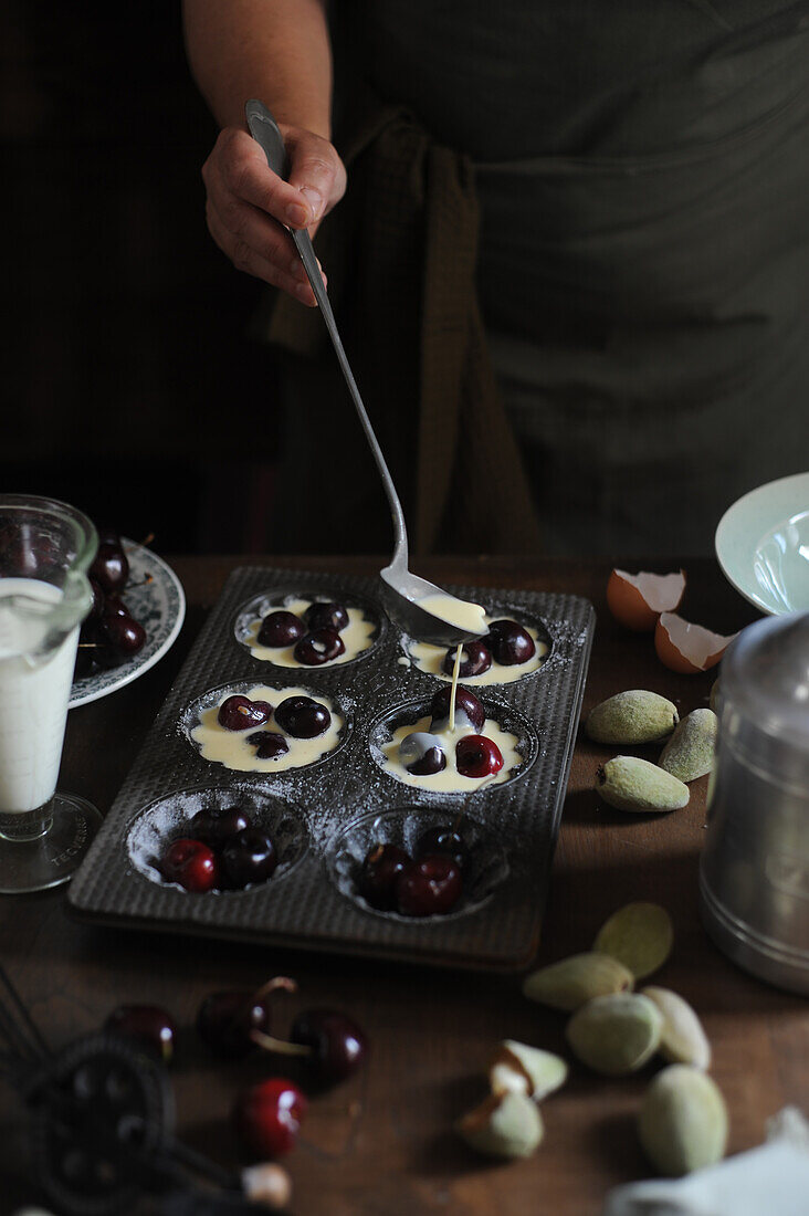 Preparing mini clafoutis with cherries