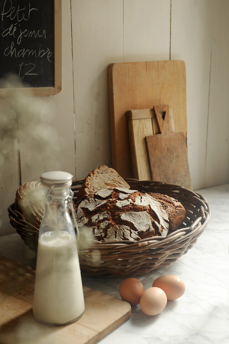Breakfast scene with bread basket, milk, and eggs
