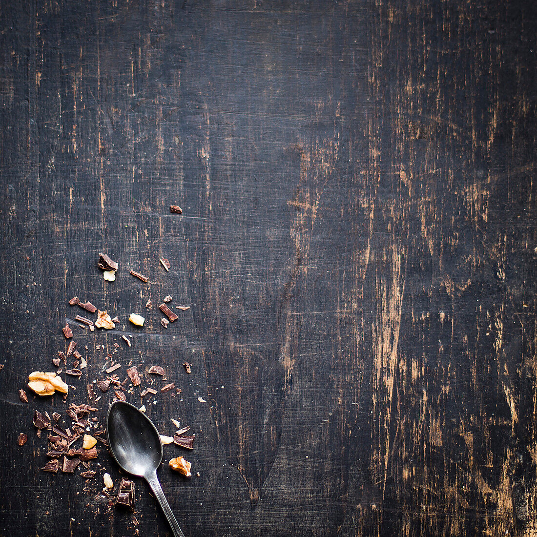 Schokoladenspäne und Walnuss-Stückchen auf dunklem Holzuntergrund