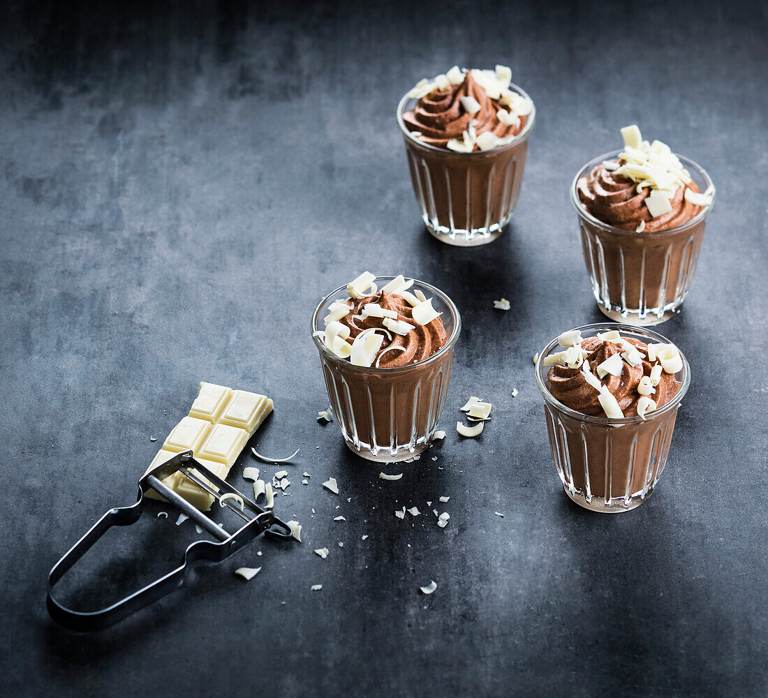 Schokoladenmousse mit weißen Schokoladenspänen serviert in Dessertgläsern