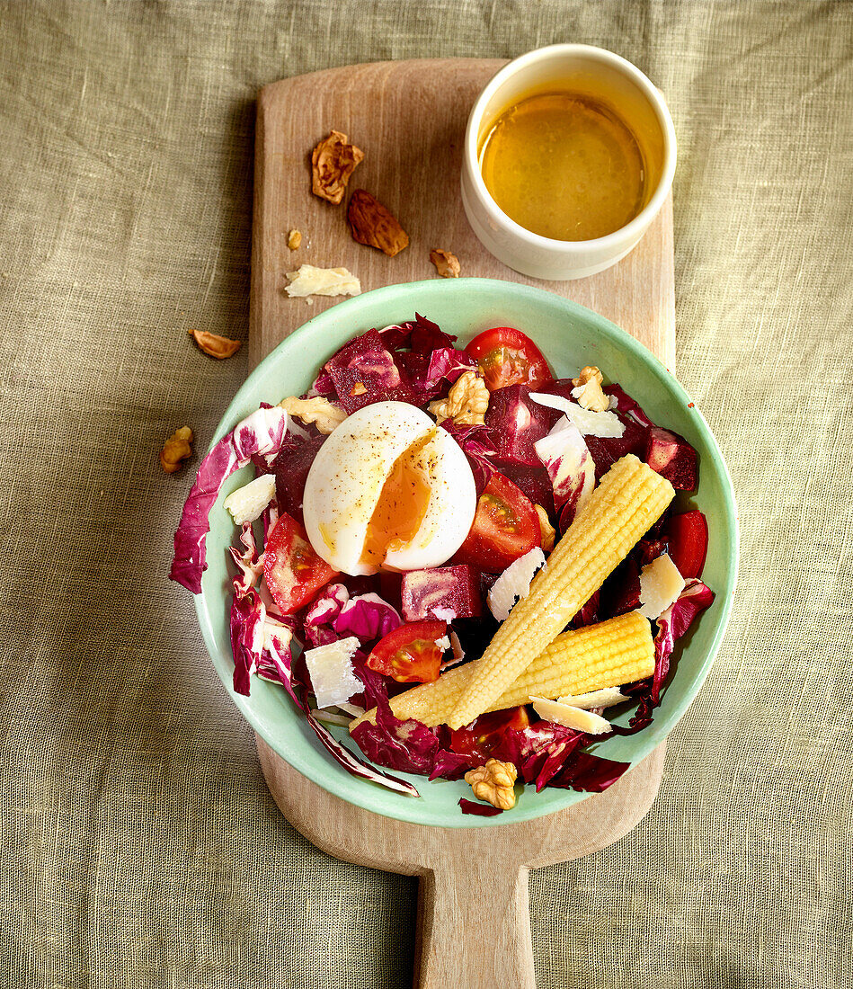 Salad with beetroot, radicchio, tomatoes, soft egg and walnuts