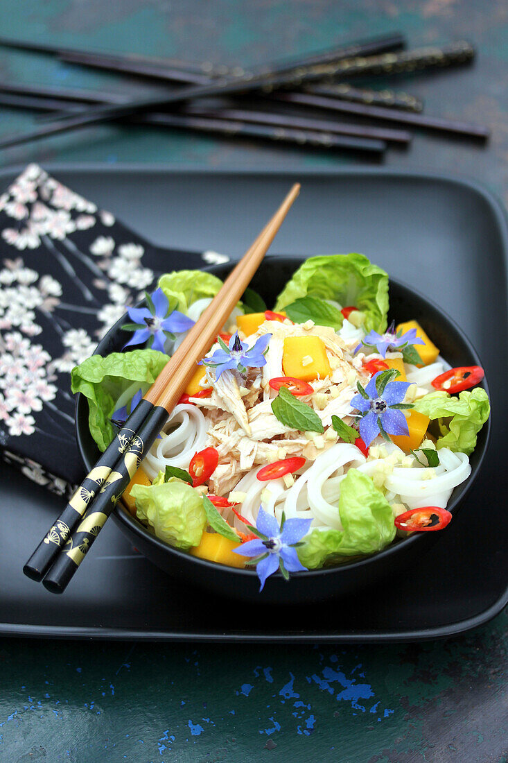 Chicken salad with Chinese noodles, mango, chillies and borage flowers