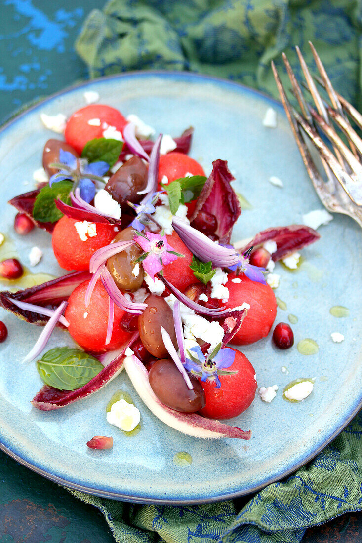 Salat mit Wassermelonenkugeln, Feta, Oliven und roten Zwiebeln