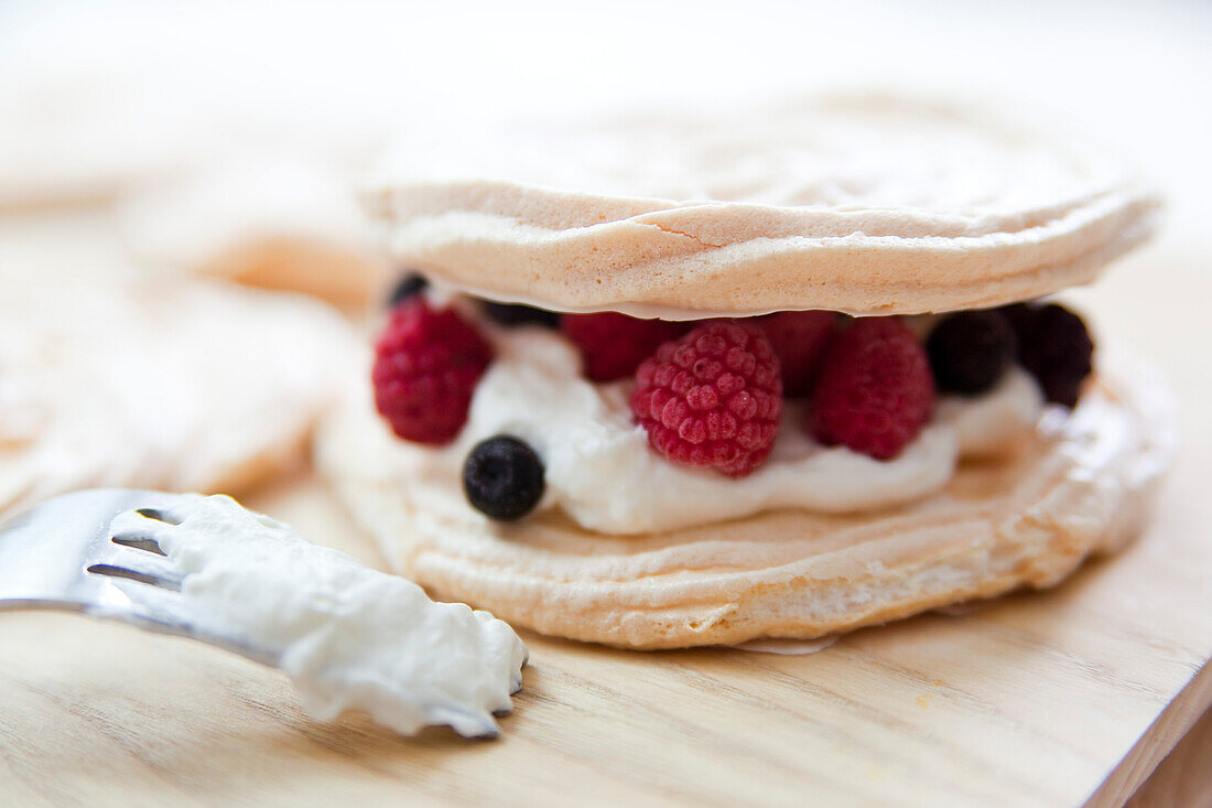 Meringues with red fruits and whipped cream