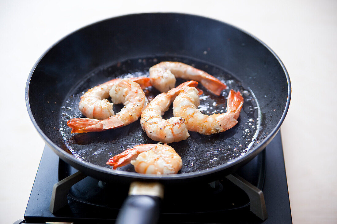 Mini-Kartoffelgratin mit Gambas in Rahmsauce zubereiten: Garnelen in der Pfanne braten