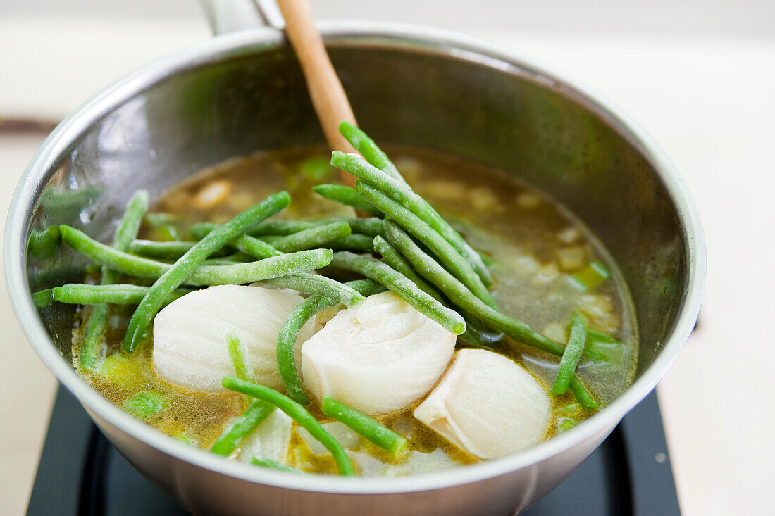 Grüne Minestrone mit Fisch zubereiten