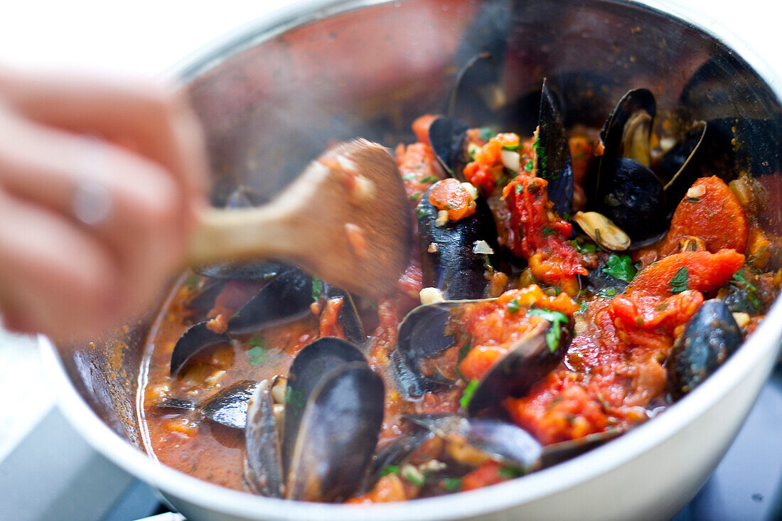 Preparing mussels with tomatoes and potatoes