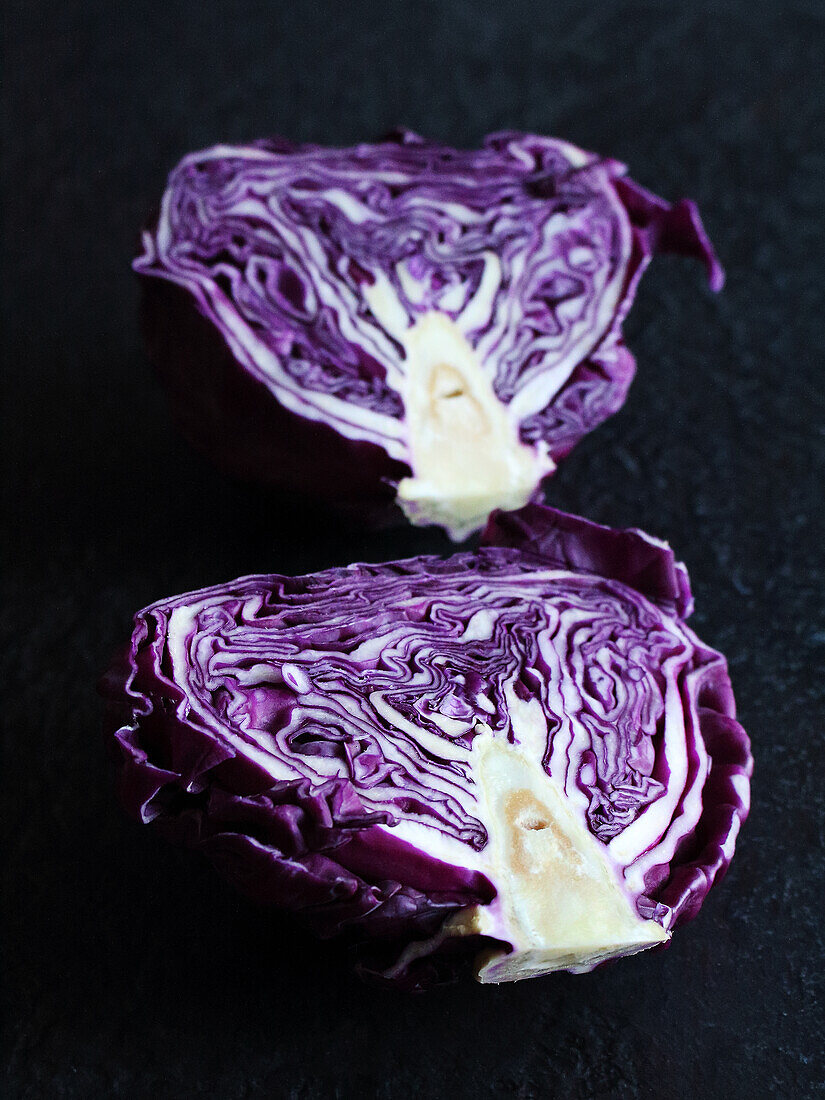 Halved red cabbage on a black background