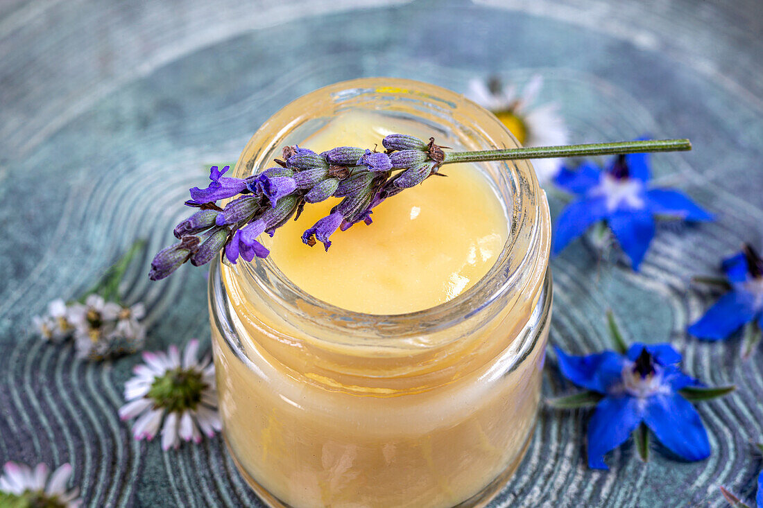 Close-up of a jar of royal jelly and a sprig of lavender