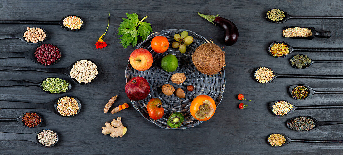 Legumes, seeds, and grains on spoons in between fruits, vegetables, and nuts