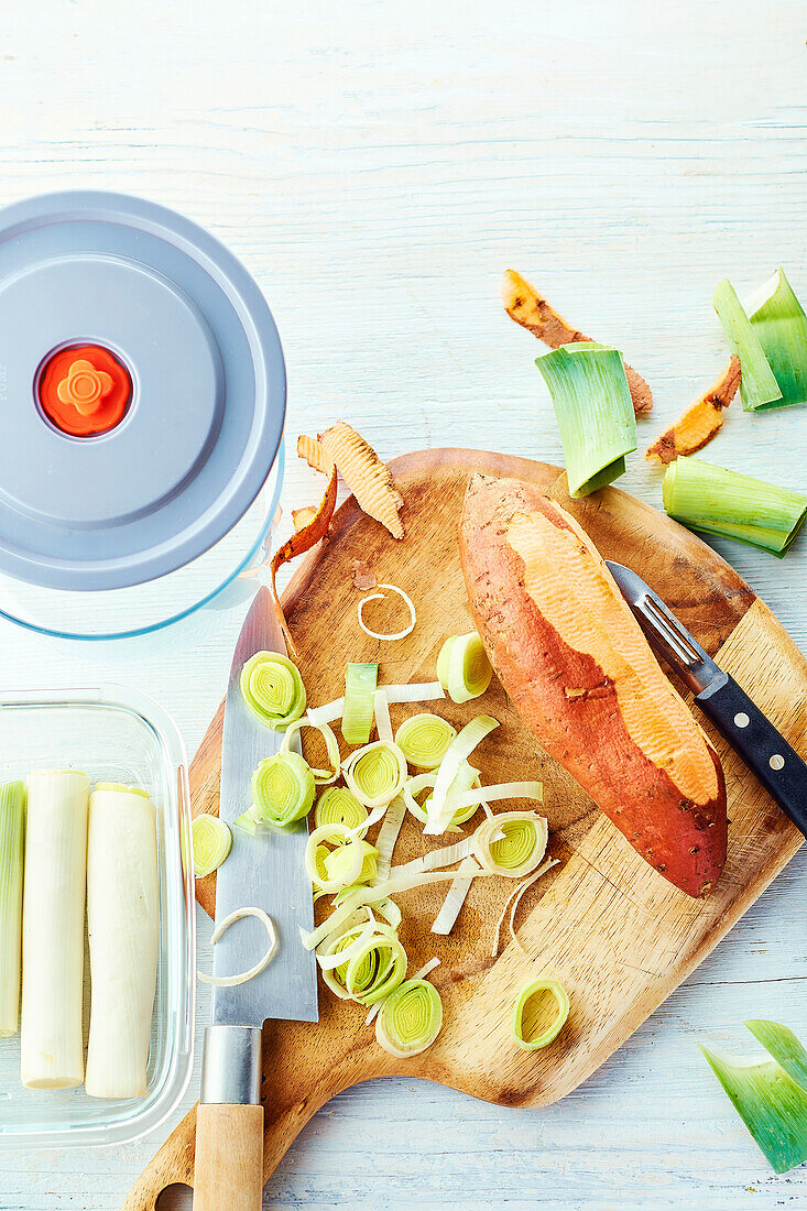 Preparing vegetables - chop leeks and sweet potatoes on a chopping board